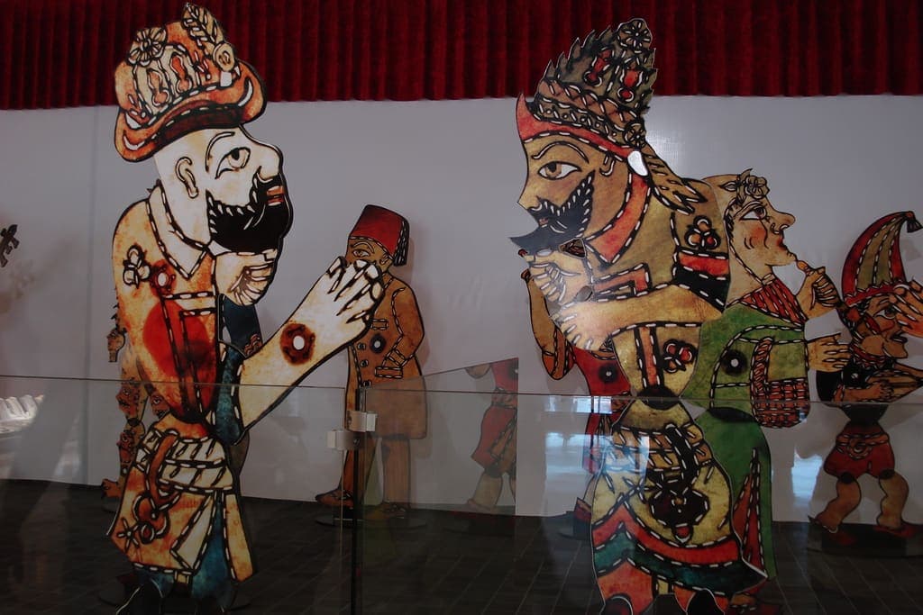 Kırmızı perdenin önünde sergilenen büyük Karagöz ve Hacivat tasvirleri