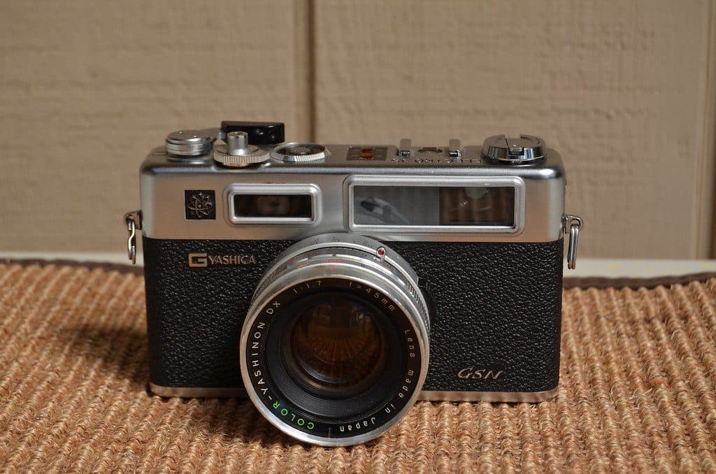 Yakın planda, gümüş gövdeli telemetreli bir analog fotoğraf makinesi