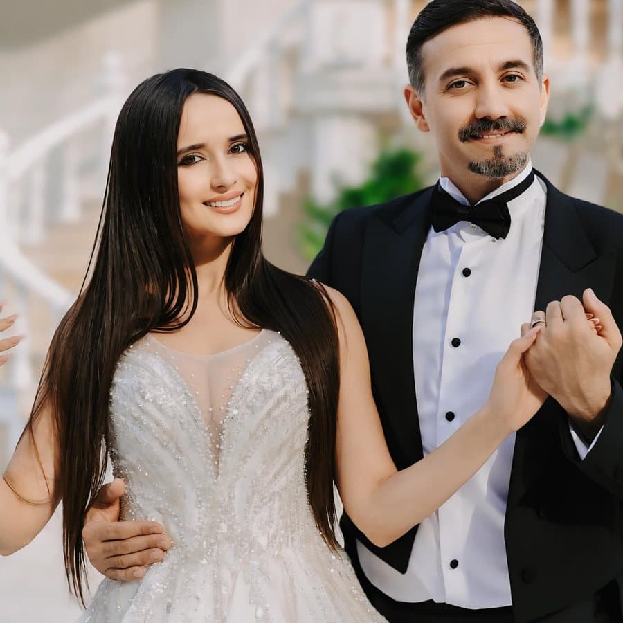 Balo salonunda vals dönüşü yapan takım elbiseli ve uzun elbiseli çift