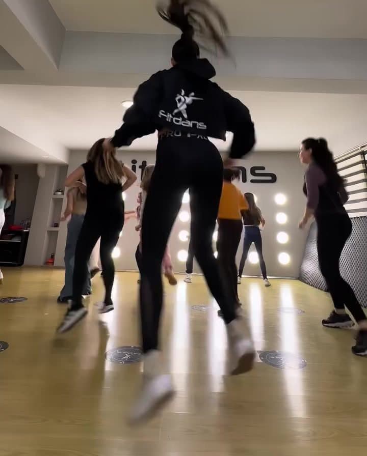 Dance cardio dersinde yüksek tempoda çalışan katılımcılar
