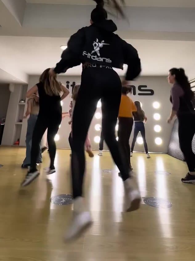 Zumba dersinde kollarını kaldırmış kalabalık grup